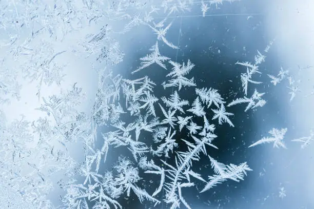 Beautiful frost pattern on a window glass, macro photo, natural winter background