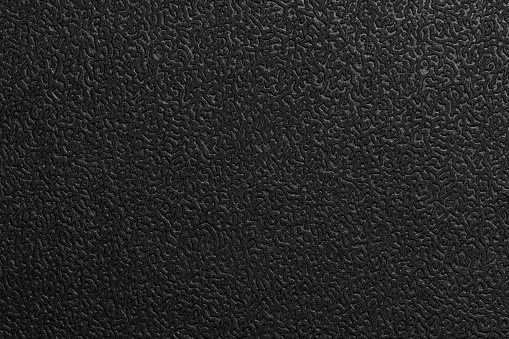 Black embossed surface, artificial leather macro photo, background texture