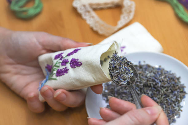 Making lavender sachet with floral embroidery at home. Zero waste DIY gift. Homemade aromatherapy Making lavender sachet with floral embroidery at home on wooden background. Zero waste DIY gift. Homemade aromatherapy. Photo with selective focus stitched image stock pictures, royalty-free photos & images