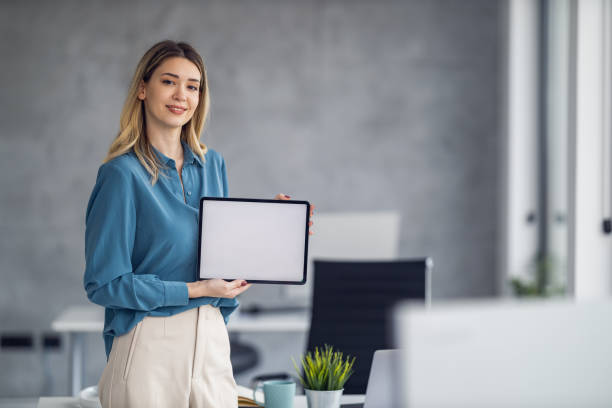 istock Woman holding digital tablet with blank white screen in office 1468622815