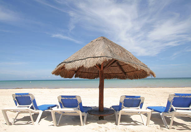 istock View of beach with umbrella and four lounge chairs 146862395