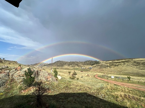 Double Rainbow on a Farm in Northern Colorado with Dark Skies and Sunshine with Mountain Views