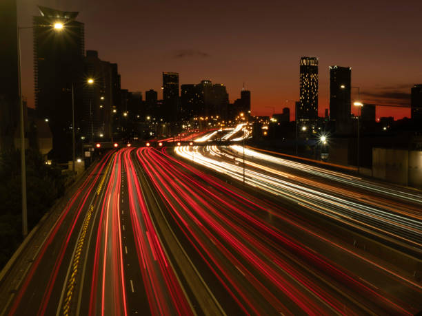 City skyline and freeway lights at sunrise stock photo