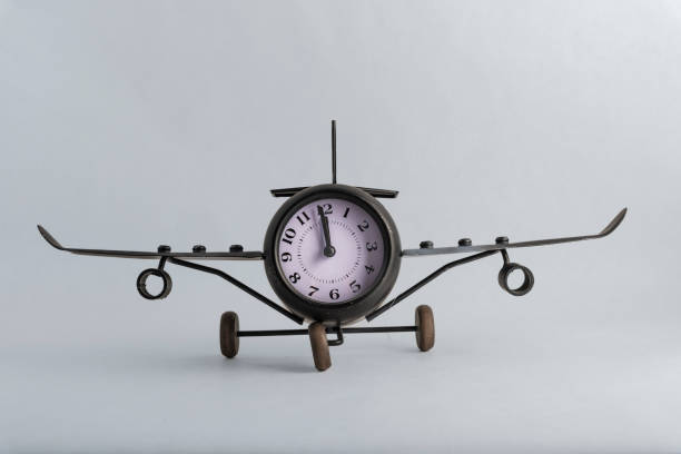 a clock in the shape of a plane with wheels stock photo