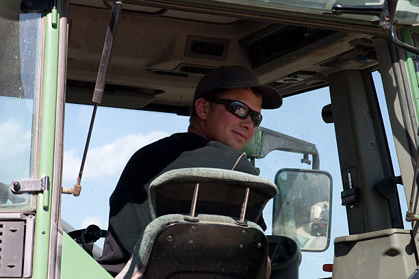 istock Smiling young farmer sitting on a tractor 146863564