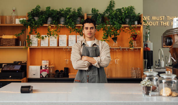 istock Young confident barista with cross hands looking straight at a camera while standing at a counter 1468639454