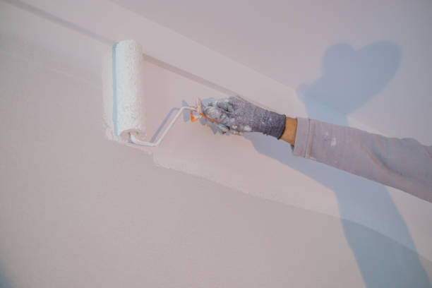 istock Man painting the wall white  with a roller 1468639481