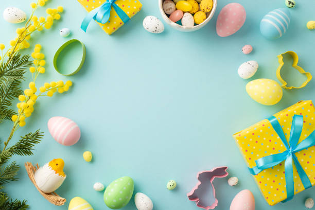 istock Easter concept. Top view photo of yellow gift boxes with blue bows bowl with easter eggs mimosa flowers chicken and baking molds on isolated pastel blue background with copyspace in the middle 1468641852
