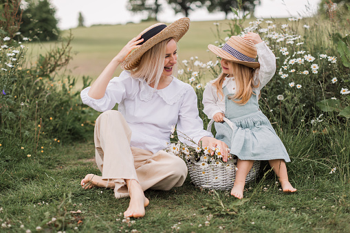 Mother and little daughter in field of daisies