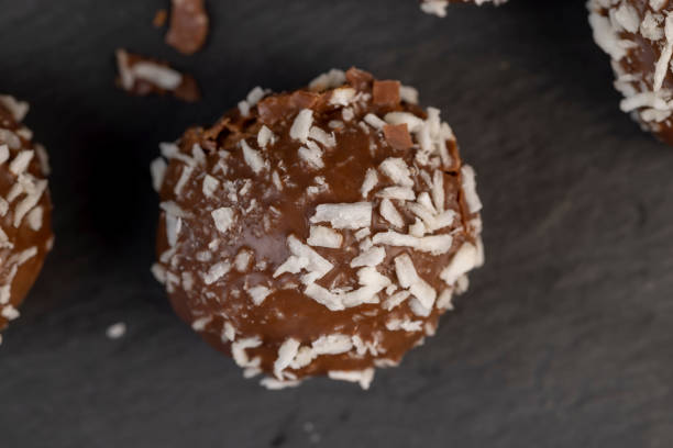Chocolate candies with milk coconut filling and coconut chips, delicious and soft chocolate coconut cakes for dessert