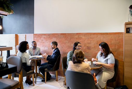 Group of multiracial businesspeople sitting in a cafe during a break from work
