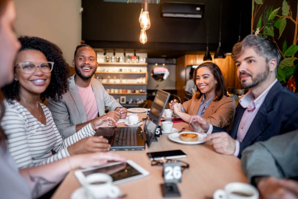 istock Diverse group of business professionals discussing work during lunch break in a cafe 1468653437