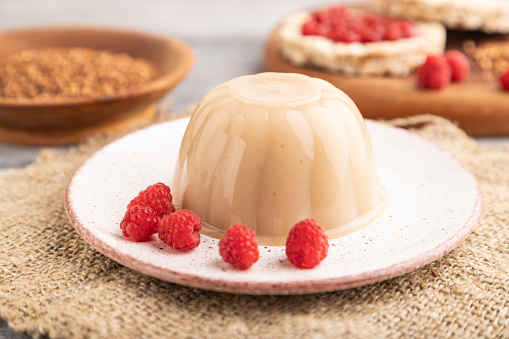 Buckwheat milk jelly on gray wooden background and linen textile. side view, close up, selective focus.