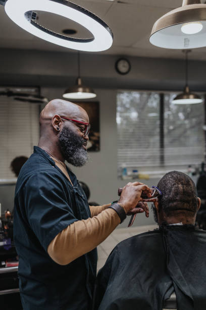 istock Black barber giving male customer a hair cut 1468654898