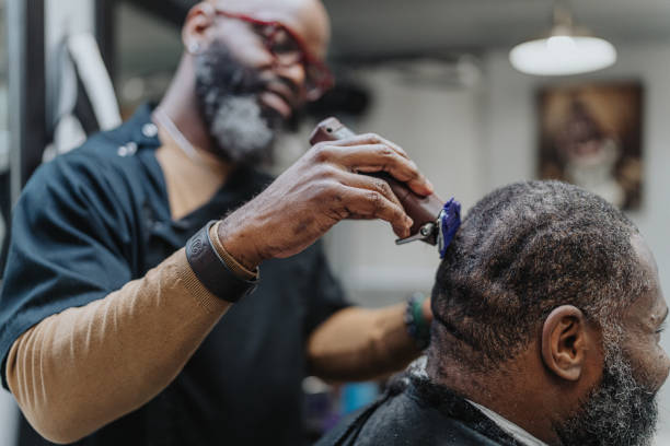 istock Barber trimming customer's hair with electric razor 1468655087