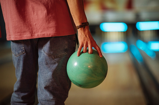 Cropped photo of a man with a bowling ball in his hand