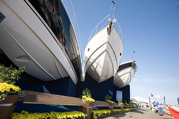 Man in a small boat looking at the luxury yachts moored in the the port de Cannes