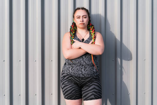 Determined woman looking at camera. Maori woman with crossed arms looking confident , looking at camera with gray background. maori weaving stock pictures, royalty-free photos & images
