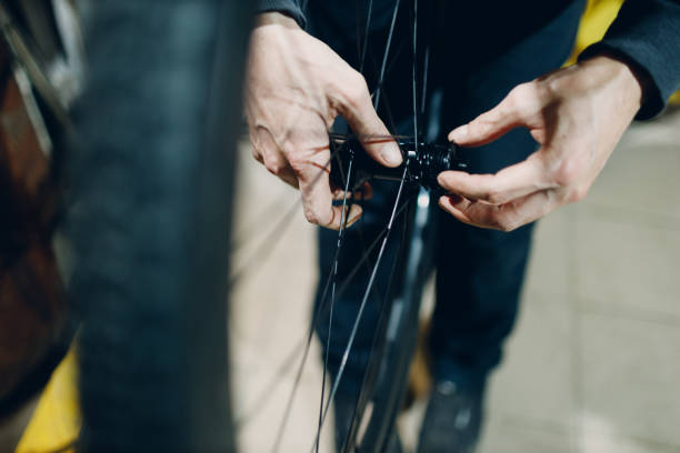 istock Mechanic repairman assembling wheel custom bicycle in workshop. 1468663035