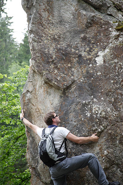 Uomo di arrampicata su roccia - foto stock