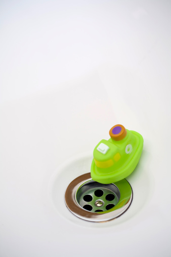 A Green toy boat in the tub