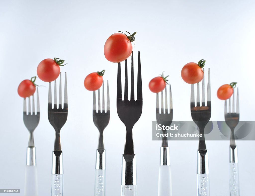 Fork and tomatoes A fresh ripe tomato on a fork. Close-up Stock Photo