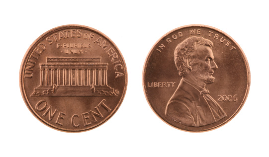 Close-up of a stack of coins, photographed against a black background.