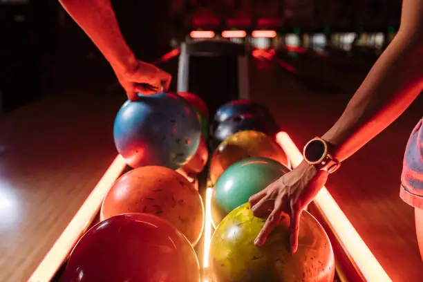 Bowling players picking up balls from the rack