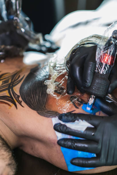 istock Deep focus of tattoo being colored with blue ink, use of biosafety elements 1468676698