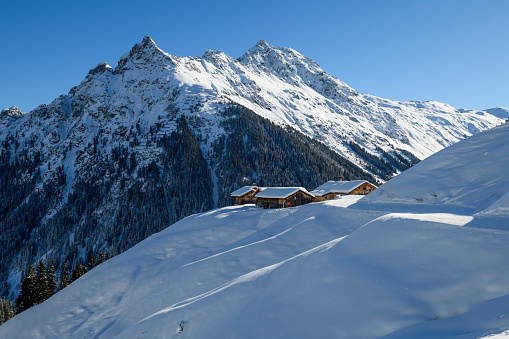 Winter landscape with snowcapped old huts in the mountains of the ski-resort Gargellen