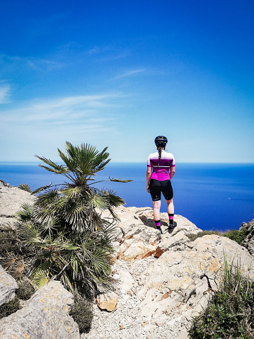 Young woman enjoying the elevated view after reaching the top by cycling in Mallorca