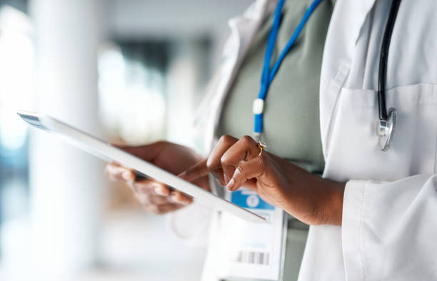 Healthcare, doctor and tablet in hands at hospital for telehealth, research and online prescription. Insurance, clinic and female with digital tech for medical report, data analysis and patient care stock photo