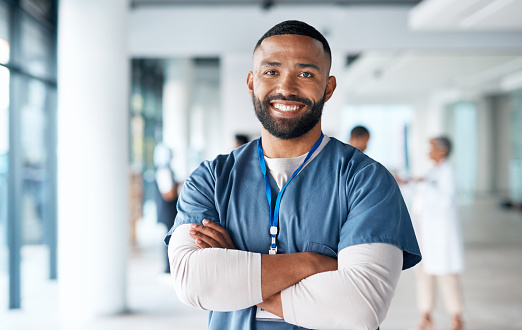 Nurse, hospital employee and portrait of black man in a healthcare, wellness and clinic feeling proud. Happy, smile and doctor in a medical facility with happiness from workplace vision and success