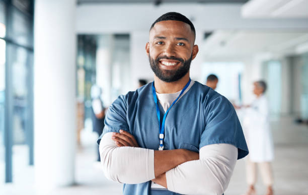 Nurse, hospital employee and portrait of black man in a healthcare, wellness and clinic feeling proud. Happy, smile and doctor in a medical facility with happiness from workplace vision and success stock photo