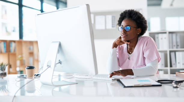 enfermera, investigadora o mujer negra en la computadora en el hospital para estudio médico, lectura de revisión de medicina o nuevo blog. pasante, estudiante o médico en tecnología para redes de atención médica, horario o agenda clínica - research medical student doctor clinic fotografías e imágenes de stock