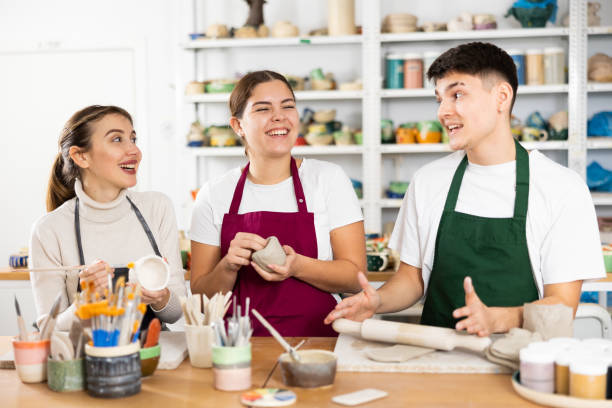 istock Two young women and young man making pottery 1468679398