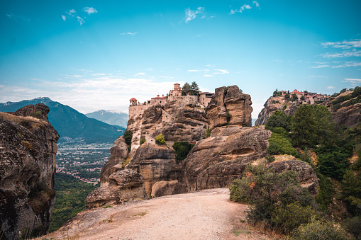 A view of Unesco World Heritage site with blue sky  in the background of a monastery on top of a hill-shaped boulder.