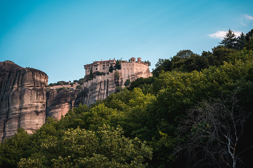 A view of hugely popular Unesco World Heritage site with white clouds in the background of a monastery, built on top of a giant boulder.