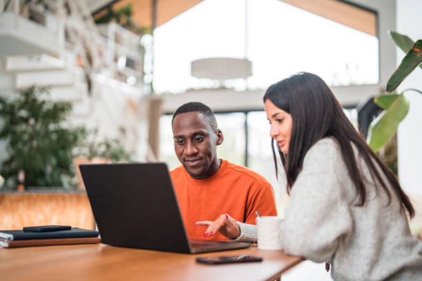 istock Mixed Race Couple Students Working With A Laptop In Modern Apartment 1468679870