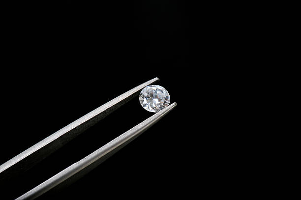 istock Diamond round cut held in jewelers tweezers 146868267