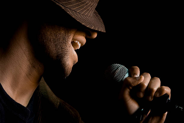 Singer on Stage A man is singing into the mic on stage. microphone stand photos stock pictures, royalty-free photos & images