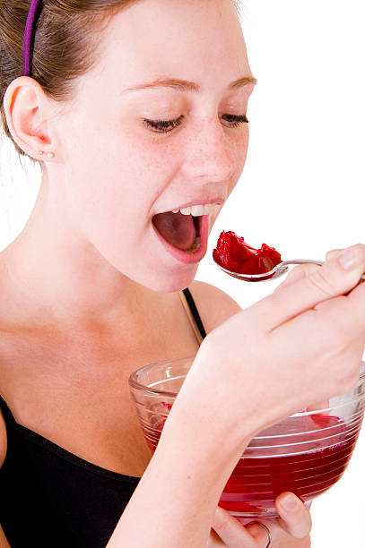 Teen girl eating jello stock photo