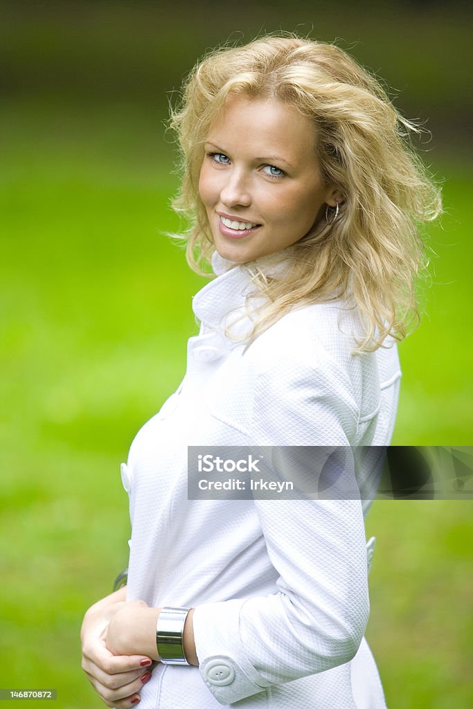 Uśmiech blonde kobieta w parku - Zbiór zdjęć royalty-free (Biały)