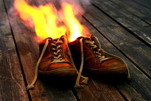 Burning old shoes; could for instance symbolize failure, sudden disappearance or total overload.