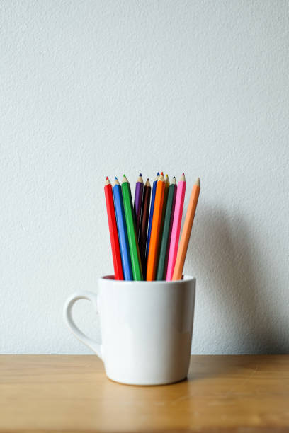 istock Stack of colored pencils in a glass on wooden background, Selective focus. 1468714187