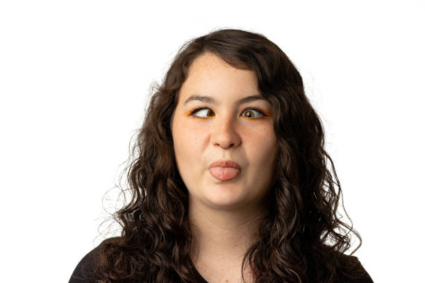 Young woman making a goofy face with crossed eyes and tongue stock photo