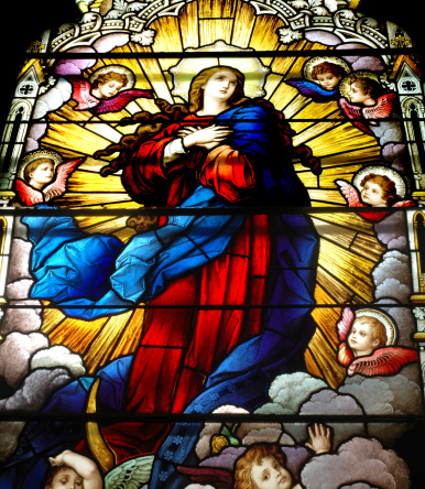 This is a photo of a stained glass window depicting the virgin Mary surrounded by angels.