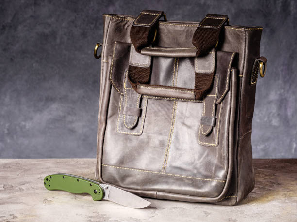 istock Green folding EDC knife near a leather business bag 1468722983