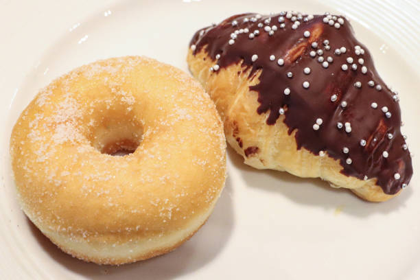 istock Full frame image of white plate of pastries including doughnut and chocolate covered croissant, elevated view 1468723474