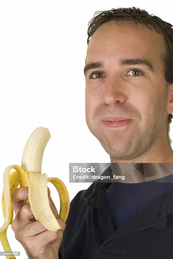 Banana Man A man chewing a fresh banana, isolated on a white background Adult Stock Photo